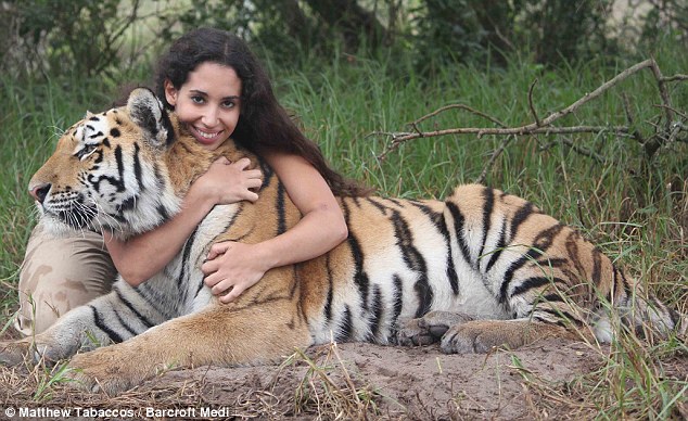 Samantha is hugging her beloved tiger pet. 